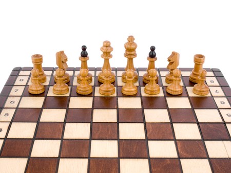 White chess-man standing at chessboard on white backgroundの写真素材