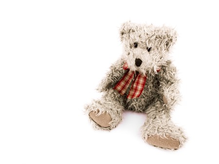 Teddy-bear with red bow on white background. On left side of picture it's empty space.の写真素材