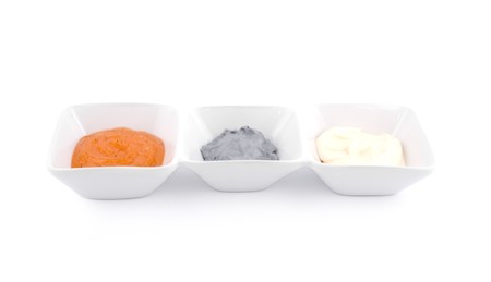 Orange peeling, grey mask and white cream in porcelain bowls on white background.の写真素材