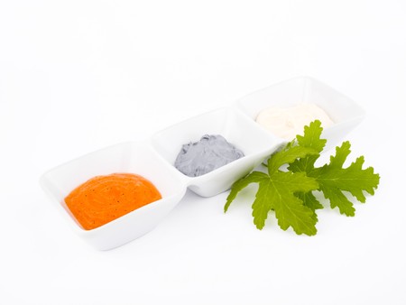 Orange peeling, grey mask and white cream in porcelain bowls on white background.の写真素材