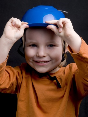 Cute little boy in blue helmet on black backgroundの写真素材