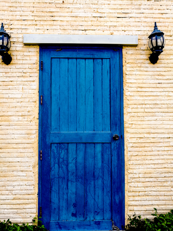 Wooden front door of  blue color and stone wallの写真素材