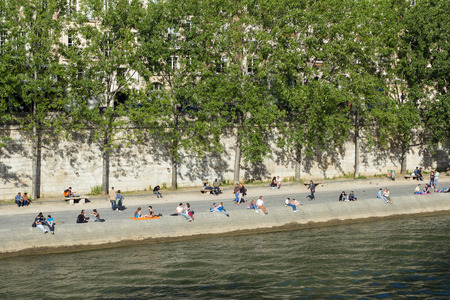 People are enjoying their free time on the banks of river Seine, in Paris, Franceのeditorial素材
