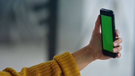 Close up woman making selfie photo on mobile phone with chroma key. Woman hands holding mobile phone...
