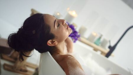 Closeup romantic woman taking bath at luxury home. Sensual girl relaxing in foam bath. Sexy woman...