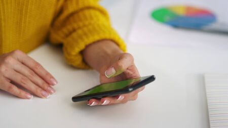 Closeup woman hands scrolling smartphone screen with chroma key in slow motion. Business woman looking green screen mobile phone. Unrecognized girl surfing internet with cell phone.の写真素材