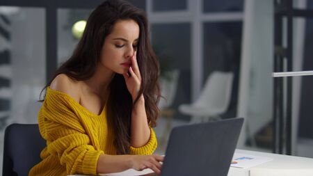 Closeup thoughtful businesswoman analyzing information on laptop in office. Tired girl reading...
