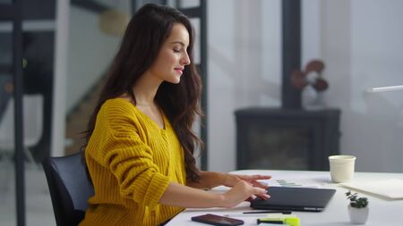 Happy business woman finishing work on laptop indoor. Close up pretty girl closing laptop in office at evening. Relaxed businesswoman meditating near computer at workplace.の写真素材