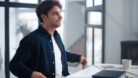 Happy business man finishing work on laptop computer indoor. Close up handsome worker closing laptop in office. Relaxed businessman meditating near notebook at workplace.の写真素材