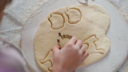 Overhead view of mother and daughter hands preparing cookies on kitchen in slow motion. Close up woman and child hands making biscuits on kitchen table. Mom and daughter cooking togetherの写真素材