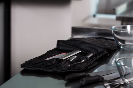 Kitchenware at kitchen restaurant. Closeup kitchen tools at professional kitchen. Knives and plates at kitchen table.の写真素材