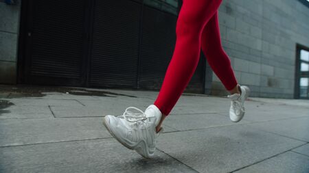 Female legs running on street road in slow motion. Close up woman legs jogging outdoor. Sport woman...