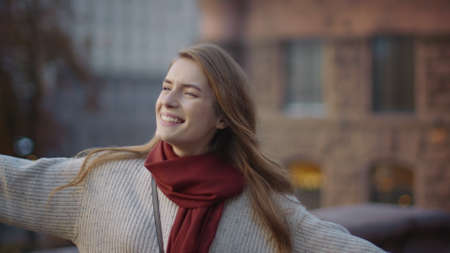 Closeup excited girl dancing on city street. Portrait of cheerful woman whirling outdoors. Pretty...