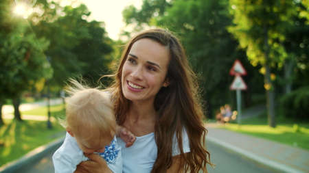 Portrait of cheerful woman and boy standing in park. Closeup happy mother and son playing with soap...