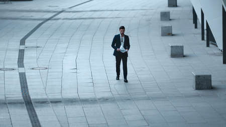 Serious businessman reading documents at street. Disappointed business man throwing papers in slow...