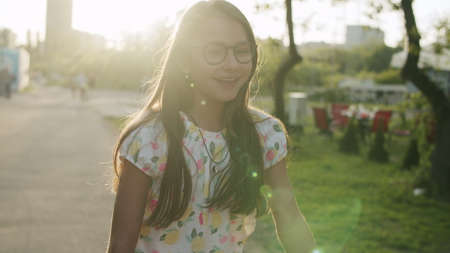 Close up smiling teenage girl jumping outside. Happy child making rhythmical movements in summer...
