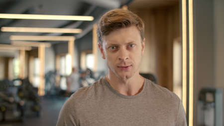 Portrait of aggressive bodybuilder screaming at gym. Closeup confident sportsman standing in fitness...