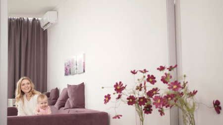 Smiling woman with baby looking mirrow. Happy family concept. Happy mother with baby laughingの写真素材