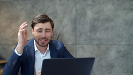 Closeup smiling businessman chatting online on laptop camera in home office. Portrait of joyful...