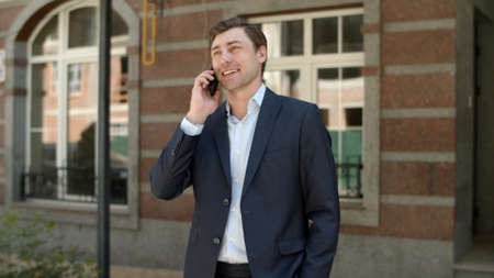 Close up confident businessman having phone talk at street. Successful man talking smartphone...