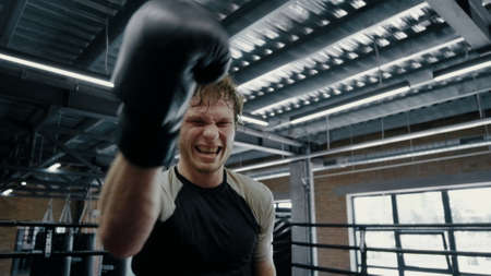 Pov view annoyed kickboxer making progress at gym. Closeup candid sportsman showing aggression on...