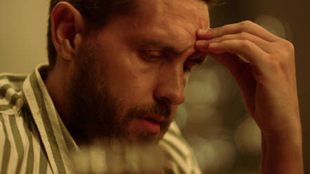 Sad man holding hand on head. Closeup thoughtful guy breathing deeply. Portrait of smiling man...
