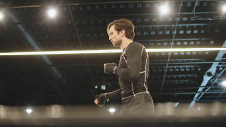 Closeup handsome fitness man doing exercises with jump rope in sport club. Focused male boxer...