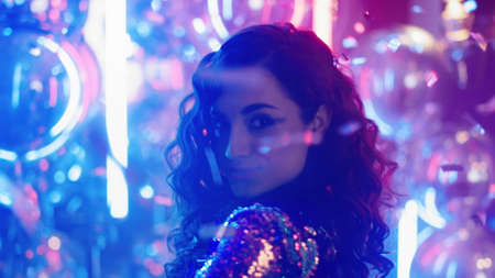 Closeup charming girl moving body on neon lamps background. Portrait of pretty female person dancing...