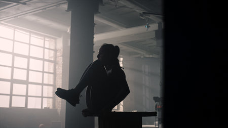 Strong woman pumping abdominal muscles in sport club. Sporty girl doing abs exercises during training session in loft building. Female athlete training press in modern gymの写真素材