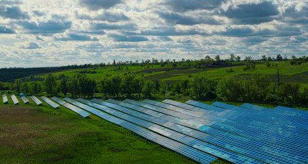 Drone shot solar batteries in green field. Sun panels park. Alternative energy source. Blue solar...