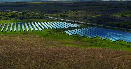 Aerial view blue solar panels park. Solar batteries farm in green field. Drone view solar panel...