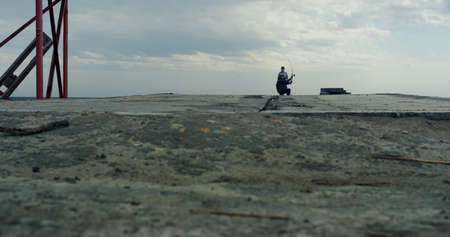 Fisherman fishing together on river pier using rod net on grey cloud weather. People catching fish...