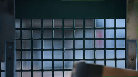 Closeup conveyor machine working process moving cardbox production against grid. Close up factory...