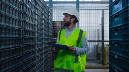Man warehouse worker checking boxes examining shipment package inspecting. Professional caucasian...
