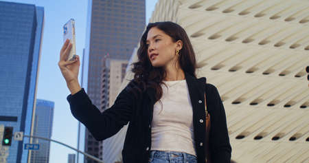 Attractive asian lady take picture high urban buildings using smartphone close up. Confident young...