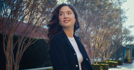 Gorgeous brunette lady turn around walking megapolis on weekend closeup. Closeup longhair asian girl...