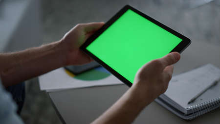 Man hands using digital tablet device chroma key researching business finance in home office....