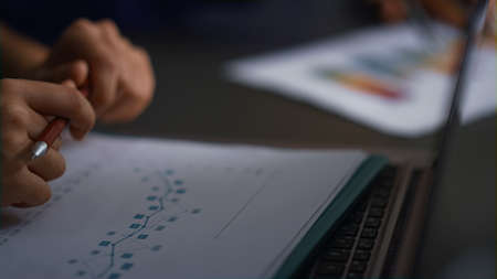 Business people consultant hands writing corporate documents researching charts in office. Close up...