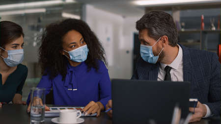 Multiracial business team brainstrom wear protection face mask in office. Diverse managers group...
