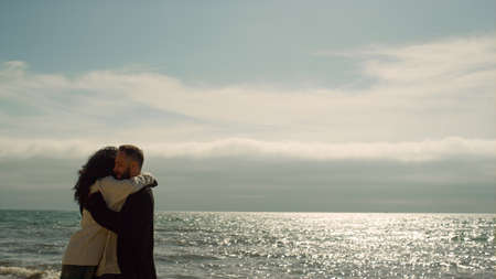 Joyful couple having fun together on vacation sea beach. Young people showing love at nature horizon line. Attractive girlfriend boyfriend spinning enjoying holiday at ocean coast. Leisure concept.の写真素材