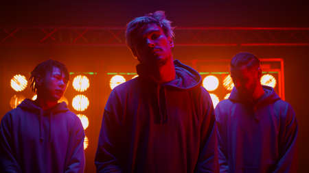 Cool freestyle team posing ready to dance performance in nightclub. Diverse men dancers looking...