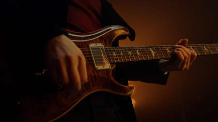 Unknown man hands playing guitar solo in nightclub closeup. Guy musician performing music at...