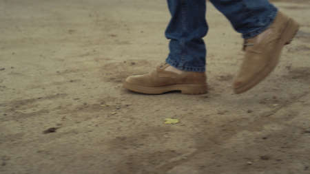 Suede boots male legs strolling closeup. Unrecognized confident man professional agronomist going...