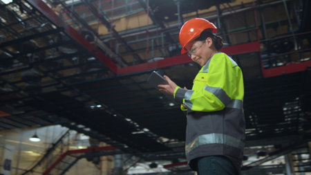 Woman supervisor holding tablet computer at huge modern manufacturing storage. Brunette industrial...