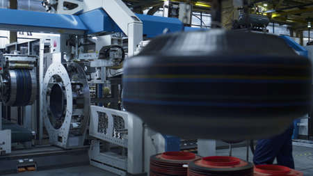 Tyre stamping plant engineers working at technological manufacture operating. Modern industrial...
