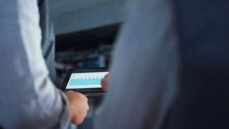 Farmer hands using tablet computer at farm closeup. Livestock agricultural job. Unrecognized...