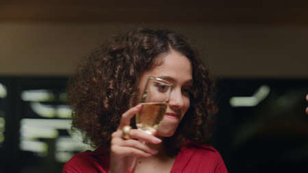 African american woman dancing in fancy restaurant. Flirting girl holding drink glass champagne in evening luxury bar. Close up beautiful sexy lady enjoying party in friends group. Having fun concept.の写真素材