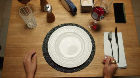 Woman eating restaurant italian food dinner in luxury cafe. Unrecognizable waiter putting plate on...