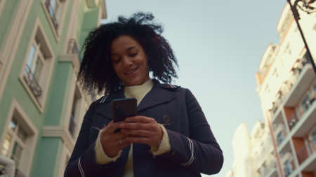 Smiling woman holding smartphone walking sunny morning closeup. Happy app user. Attractive joyful...