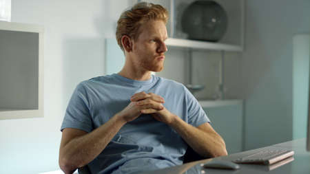 Serious manager contemplating working at home. Focused data analyst closeup. Thoughtful redhead man...
